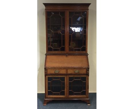 An Edwardian glazed mahogany bookcase on bracket feet. Est. £60 - £80.