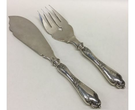 FABERGÉ: A pair of rare silver fish servers, the handles attractively decorated with scrolls. Punched to base. Approx. 296 gr