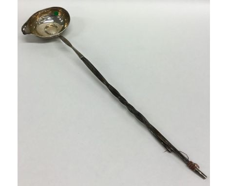 A Georgian silver mounted toddy ladle inset with bowl. Approx. 40 grams. Est. £20 - £30.