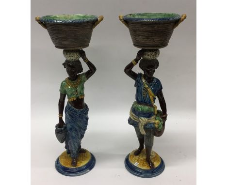 A good pair of pottery Blackamoor figures in blue and green ground with detachable planter tops. Approx. 40 cms high. Est. £1
