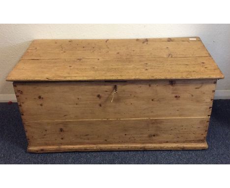A large pine hinged top trunk. Est. £20 - £30.