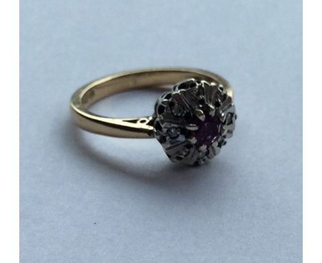 A small ruby and diamond cluster ring in 18 carat mount. Approx. 3.5 grams. Est. £60 - £80.