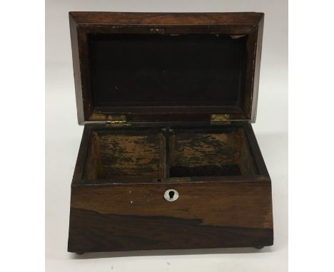 A rosewood sarcophagus shaped tea caddy on ball feet. Est. £25 - £35.