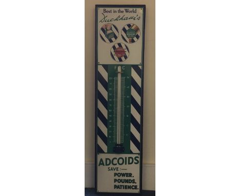 A "Best In The World Duckham's Adcoids Save: Power, Pounds, Patience" metal and enamel thermometer mounted on wooden stand. A