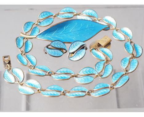 A David Anderson silver gilt and blue enamel suite of jewellery, including necklace, brooch and ear clips, of leaf-shape desi