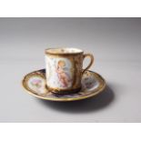 A Sevres style cabinet cup with cherub and monogram decoration on a brown ground, a similar saucer