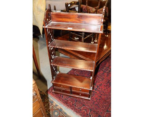 A mahogany fretwork four-tier open shelf, fitted four drawers, on bracket feet, 21" wide x 7 1/2" deep x 44" high, and a&nbsp