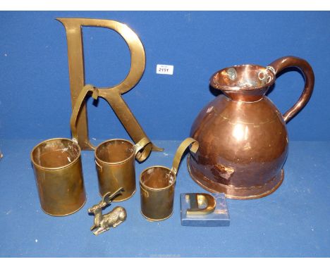 A small quantity of brass to include: a set of three graduated milk measures, copper 1 gallon measuring jug, horse brass "R",