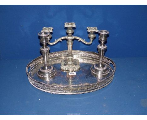 A plated galleried oval tray, a candelabra and a pair of candlesticks.
