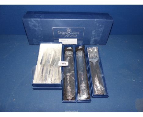 A boxed cheese and tea knives, a bread knife and fork with Sheffield silver handles by United Cutlery.