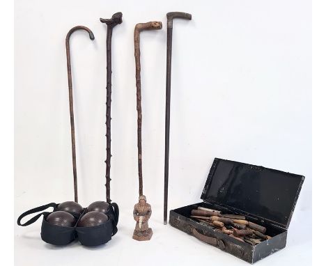 Set of four wooden bowls in carry case, a collection of five walking canes, one with silver collar, a carved wooden figure of