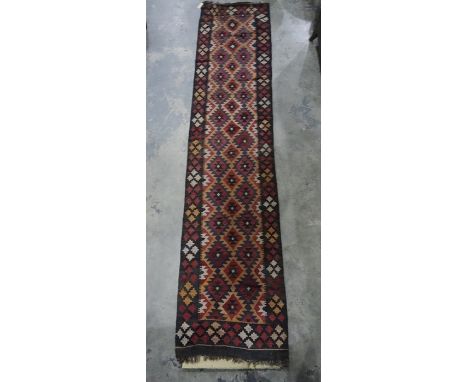 Eastern runner with repeating diamond-shaped tribal pattern, in reds, blues and peaches, thick border with repeating pattern,