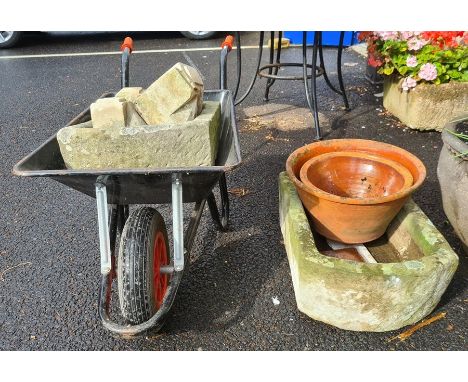 Gardeners wheelbarrow containing D-end stone trough and four stone cornice pieces, another D-end stone trough (cracked) and t