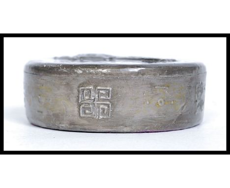 A vintage lead decorated Indian / Chinese paperweight, decorated with a figure to top and symbols to side. It is 6.50dia and 