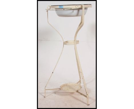 An early 20th century painted cast iron washstand with enamel bowl set atop