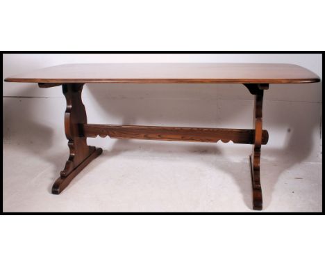 A large Golden Dawn Ercol refectory dining table raised on lyre shaped supports. This being the large example with elm chamfe