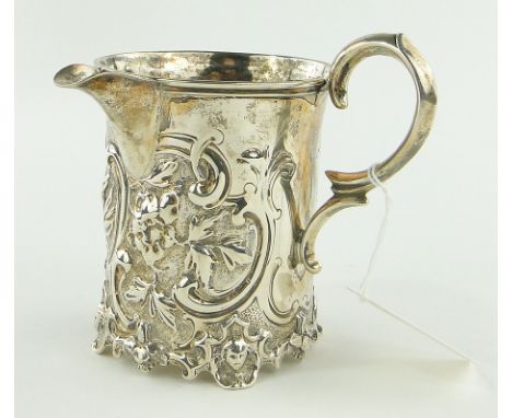 A Victorian silver cream jug,
with chased floral designs and panel depicting a sailor boy, makers marks W K R, London 1854, h
