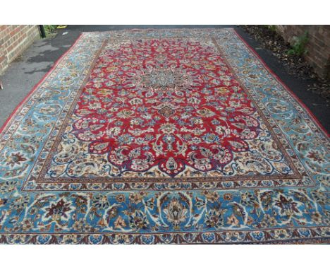 A large red ground wool Persian design carpet 
with allover symmetrical patterns, 15' x 12'.
