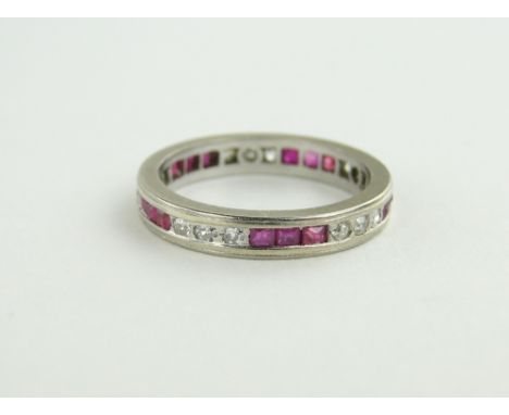Unmarked platinum ruby and diamond set full eternity ring, 
size L.