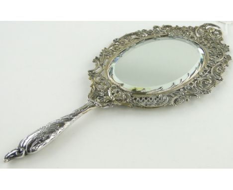 An ornate French silver hand mirror
with cast cherub decorated surround, indistinct continental marks, length 32cm.