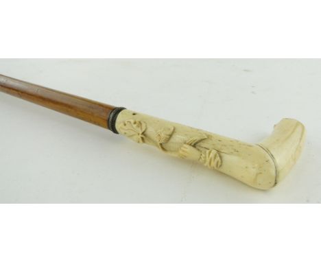 A Georgian walking stick
with carved ivory handle depicting a hand holding a acorn and oak leaf.