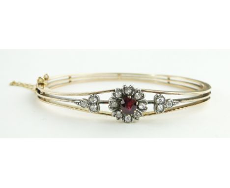 Unmarked gold hinged bangle
set with rubies and diamonds.