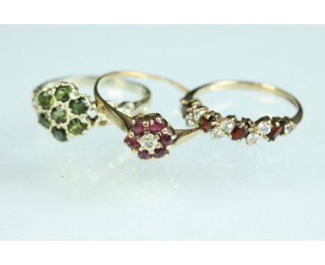 Peridot 9ct gold flower head cluster ring, cast scroll shoulders, ring size M; a garnet and paste 9ct yellow gold ring, size 