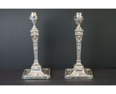 Pair of early 20th Century Edwardian silver hallmarked candlesticks of neo classical design. The candlesticks having urn desi