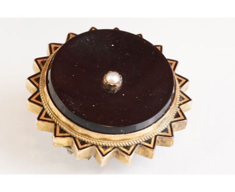 Late 19th century onyx, seed pearl and black enamel yellow metal brooch, glazed panel verso, hinged pin and simple loop brooc