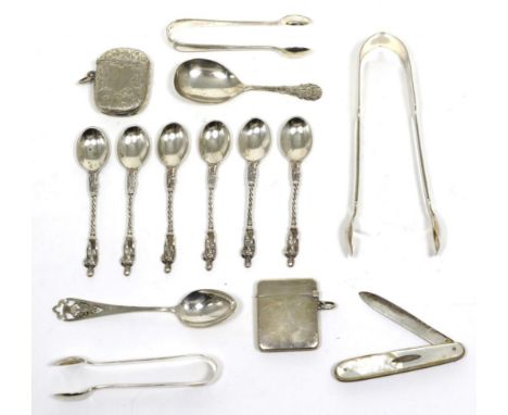 A group of silver comprising two vestas, three sets of tongs, a set of six apostle spoons, an Edinburgh teaspoon, caddy spoon