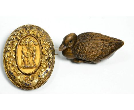 A silver gilt brooch decorated with Adam and Eve together with a carved wooden Japanese netsuke in the form of a duck (2)