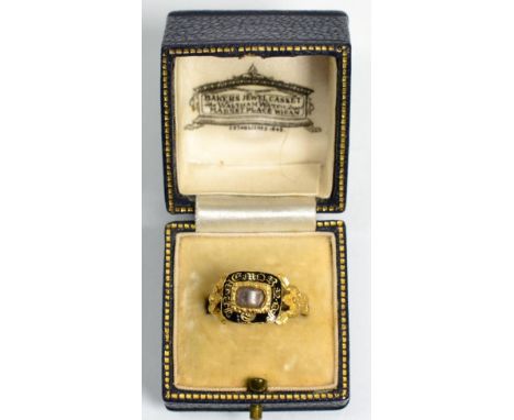 An 18 carat gold mourning ring, a central glazed panel containing hairwork, within a black enamel border with 'In Memory Of' 