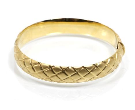 A brushed polished bangle, with lattice motif, measures 5.5cm by 6cm, stamped '750'.  25.8g