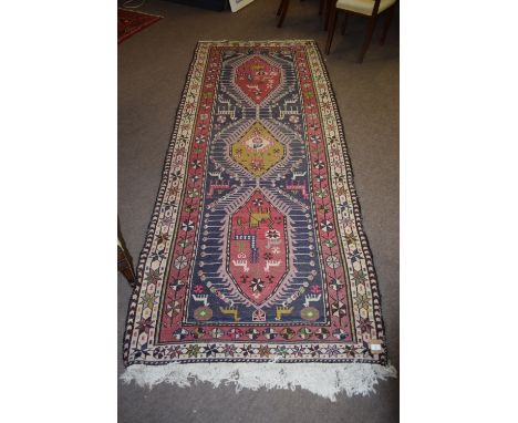Caucasian large wool runner, double gull border, central panel of three interlinked lozenges with geometric animals etc, main