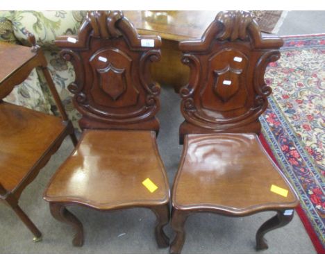 Pair of Victorian mahogany hall chairs with C-scroll moulded arch backs solid seats and cabriole front supports