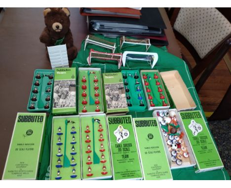 Subbuteo football teams in green boxes, nets and a soft toy bear. 