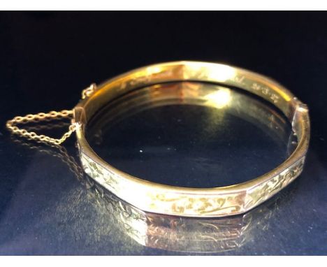 9ct fully hallmarked Gold bangle with floral engraving, good clasp and safety chain total weight approx 10.5g