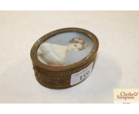 A gilded oval trinket box, the lid with painted miniature portrait panel of a young lady with roses in her hair