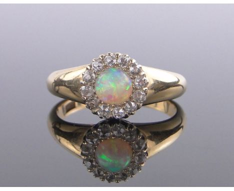 An 18 ct gold opal & diamond cluster ring, setting height 10 mm, size P