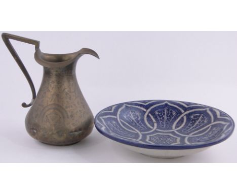 A Middle Eastern blue & white painted ceramic bowl,13" diameter, & a Middle Eastern engraved brass jug (2)