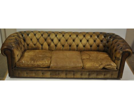 A Brown leather studded upholstered Chesterfield sofa with rollover arms & loose cushions, length 8' 5", height 2' 4"