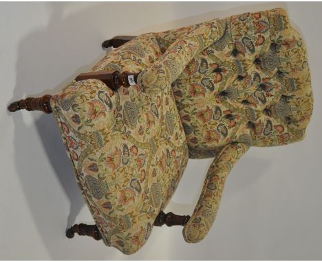 A 19th century button upholstered open armchair on turned legs