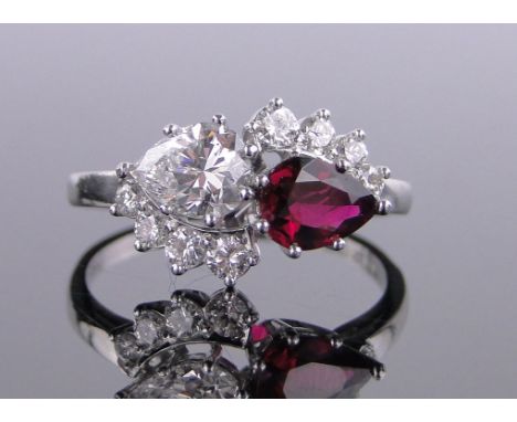 A 2 stone pear shape ruby & diamond crossover ring,surrounded by smaller diamonds, main diamond approx 0.79 carats, ruby appr