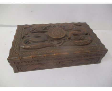 A World War II Indian carved hardwood cigarette box decorated with two mythical creatures and inscribed Royal Army Medical Co