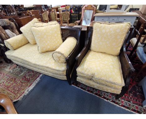 An early 20th century mahogany bergere sofa and matching armchair with double caned sides and carved ram's head motifs Locati