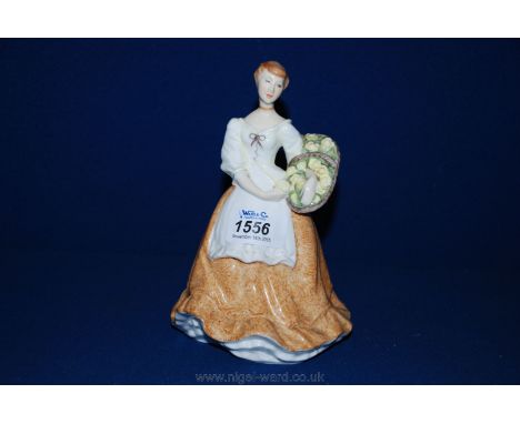 A Royal Worcester figure of a young girl with a basket of flowers.
