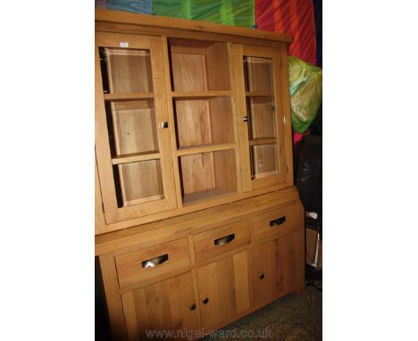 A modern bespoke made oak Dresser with plain top over a central open shelf compartment with two shelves flanked by opposing s