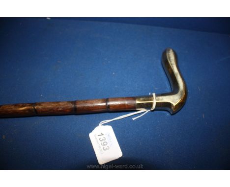 A walking Stick with shaped gold coloured metal handle.