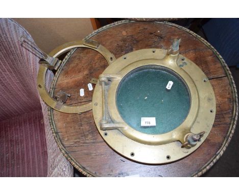 A brass porthole and round brass sight
