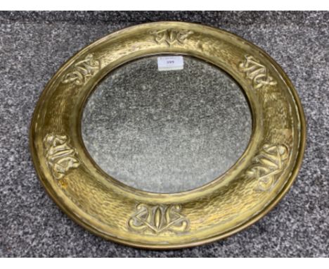 An arts &amp; crafts circular bevelled glass mirror, brass framed with bark &amp; Celtic knot design